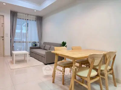 Modern living room with cozy sofa and dining area in open layout apartment.
