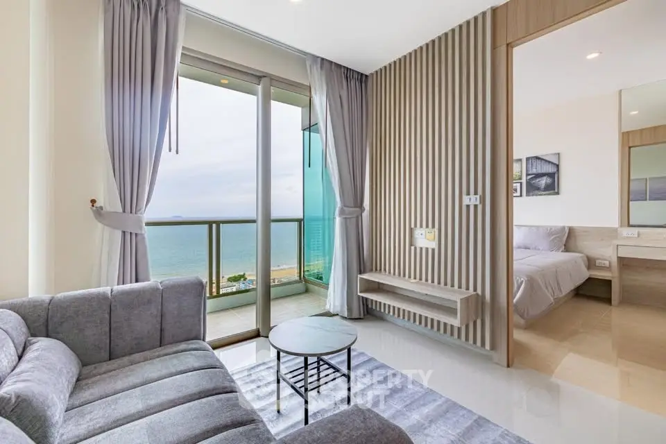 Modern living room with ocean view and adjacent bedroom in luxury apartment