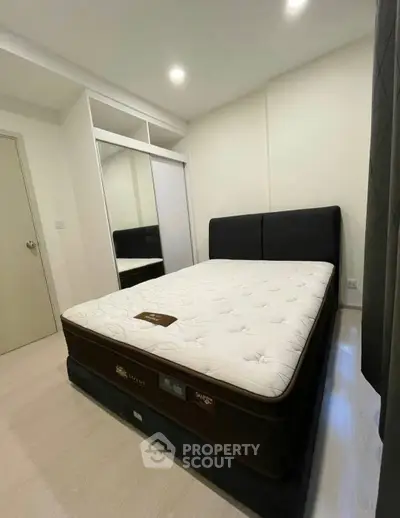Modern bedroom with plush mattress and sleek wardrobe in a cozy apartment.
