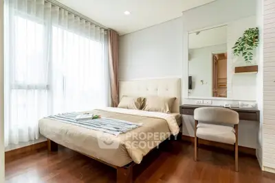 Elegant bedroom with large window, cozy bed, and stylish decor in modern apartment.