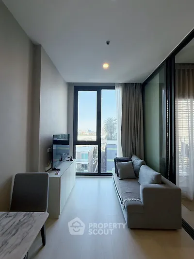 Modern living room with large windows and balcony view in a stylish apartment.