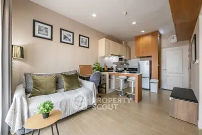 Modern living room with cozy sofa and stylish kitchen in open layout apartment.