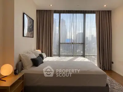 Luxurious bedroom with city view, modern decor, and ample natural light.