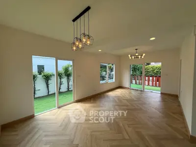 Spacious living room with elegant lighting and garden view, perfect for modern living.