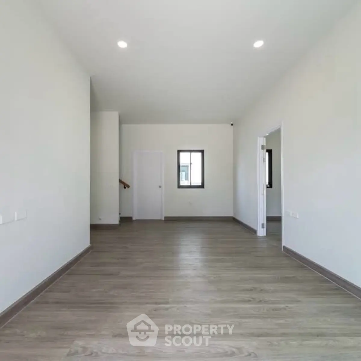 Spacious empty room with modern flooring and bright lighting, perfect for customization.