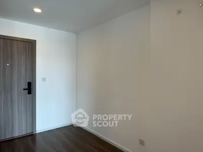 Minimalist interior with wooden door and white walls, perfect for modern living.