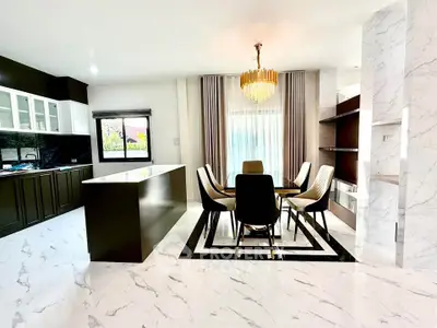 Luxurious modern kitchen and dining area with elegant chandelier and marble flooring