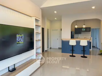 Modern open-plan living room with sleek kitchen and stylish bar stools