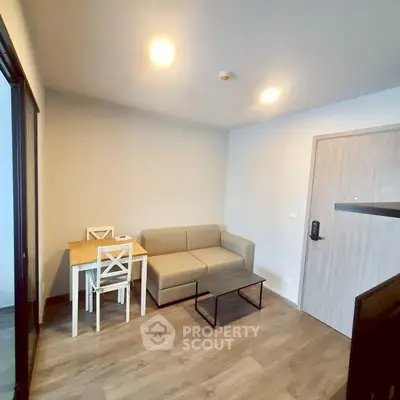Cozy living room with modern sofa and dining set in a compact apartment.