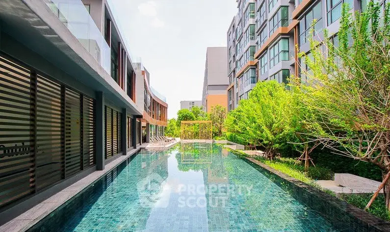 Luxurious modern apartment complex with stunning pool and lush greenery