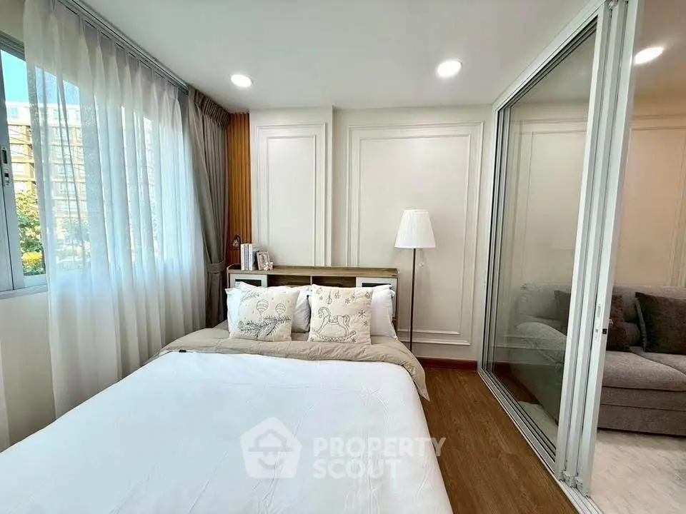 Cozy bedroom with modern decor and large window for natural light