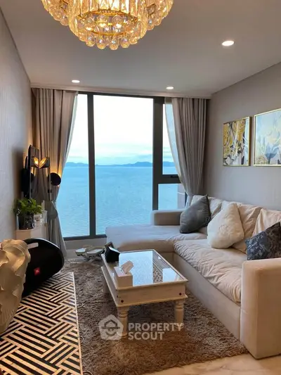 Luxurious living room with stunning ocean view, elegant chandelier, and modern decor.
