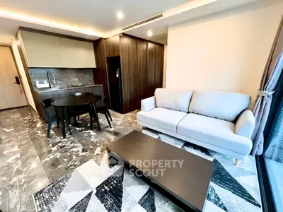 Modern living room with open kitchen, stylish furniture, and elegant marble flooring in a contemporary apartment.