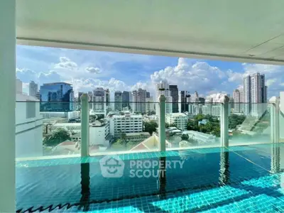 Stunning rooftop pool with panoramic city skyline views in luxury high-rise building.