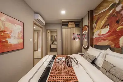 Modern bedroom with stylish decor and spacious layout, featuring a large bed and vibrant artwork.