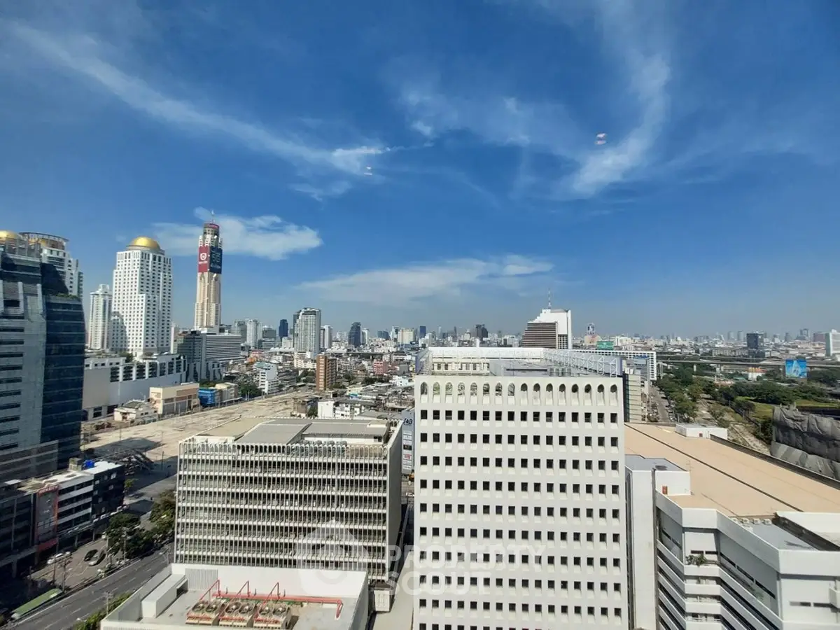 Stunning cityscape view from a high-rise building showcasing urban skyline under a clear blue sky.