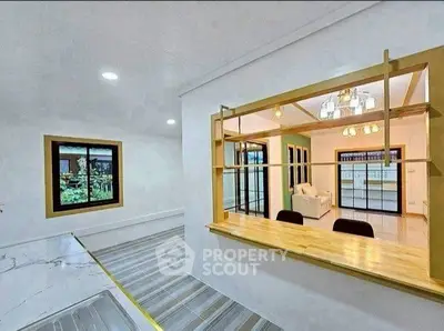 Modern open-layout kitchen with stylish wooden counter and elegant lighting.