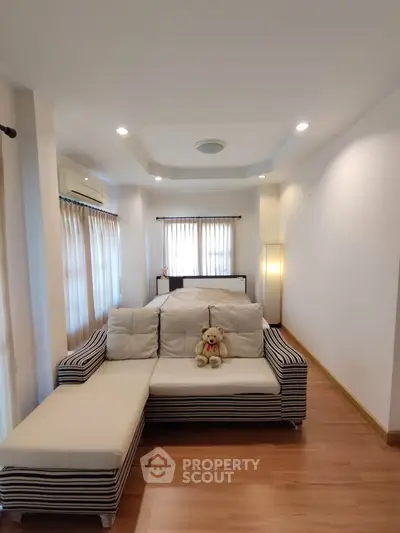 Spacious living room with cozy striped sofa and natural light