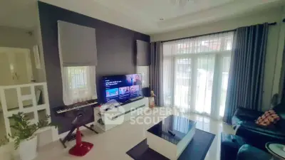 Modern living room with large windows, stylish decor, and entertainment setup.