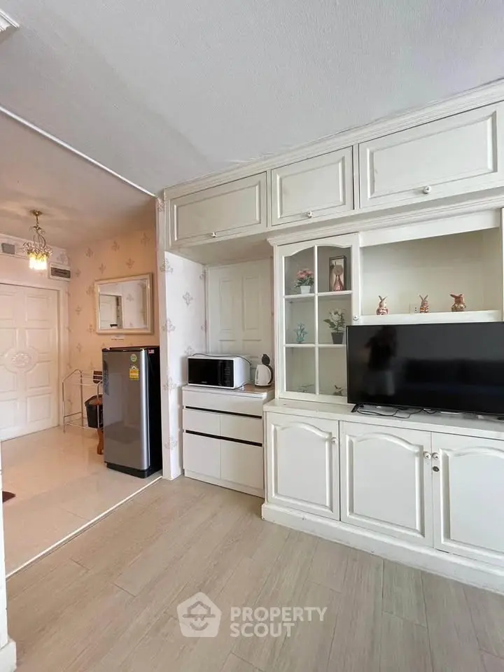 Charming living room with built-in cabinets and modern appliances