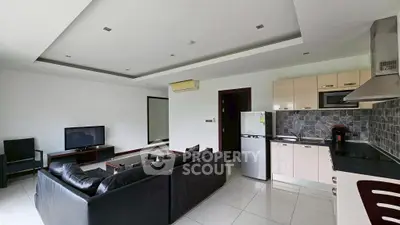 Modern open-layout living room with sleek kitchen and leather sofa