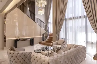 Luxurious living room with elegant staircase and plush seating in a modern home.