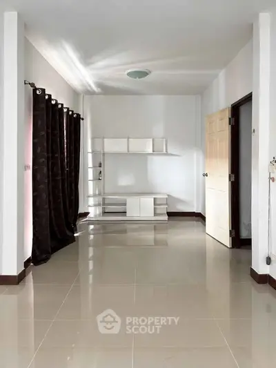 Spacious empty room with glossy tiled floor and modern shelving unit
