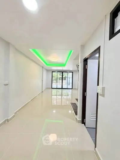 Modern living room with sleek design and green accent lighting