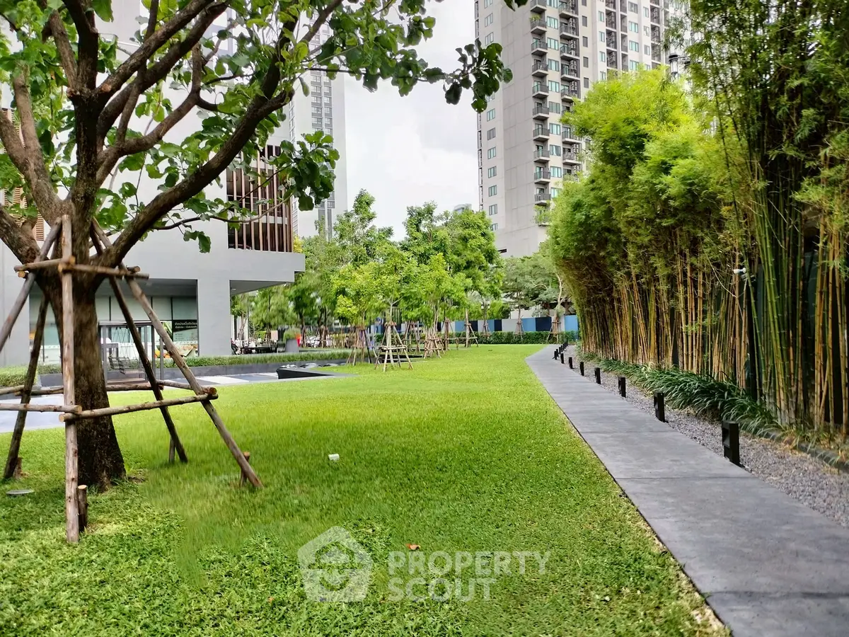 Lush garden area with modern high-rise buildings, perfect for urban living.