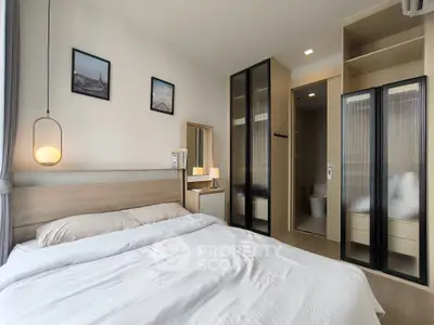 Modern bedroom with stylish decor and ensuite bathroom in a contemporary apartment.