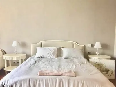 Elegant bedroom with cozy bed and stylish side tables in a serene setting.