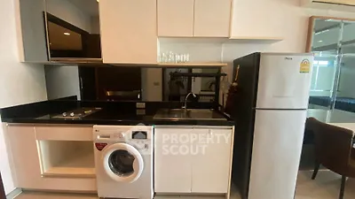 Modern kitchen with sleek appliances including washing machine and fridge, ideal for urban living.