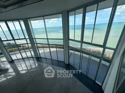 Stunning ocean view from a spacious modern living room with floor-to-ceiling windows.