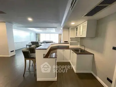 Spacious open-plan living room with modern kitchen and elegant bar seating