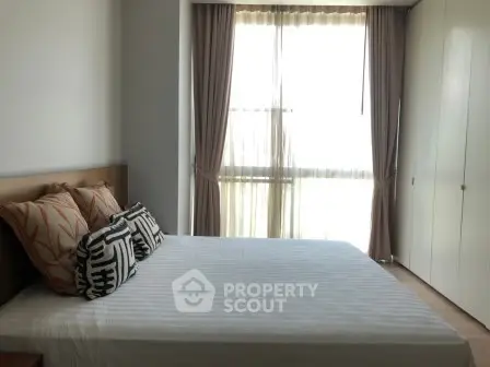 Modern bedroom with large window and stylish decor in a contemporary apartment.
