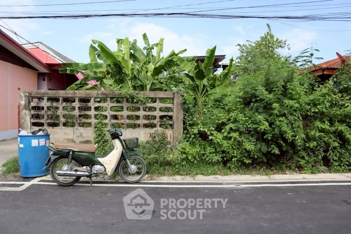 Charming suburban street view with lush greenery and classic motorbike parked roadside.