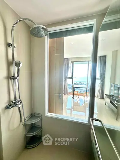 Modern bathroom with large window offering stunning sea view