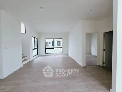 Spacious modern living room with large windows and wooden flooring