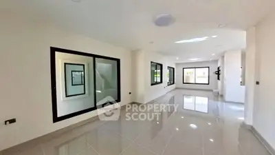 Spacious modern living room with large windows and glossy tiled floors
