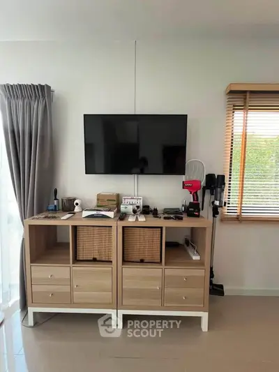 Modern living room with sleek TV setup and stylish storage solutions.