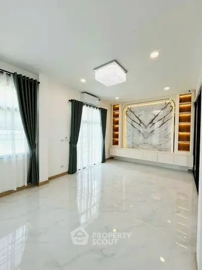 Spacious modern living room with elegant marble feature wall and large windows.