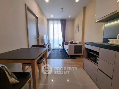 Modern open-plan living room with sleek kitchen and cozy seating area, perfect for urban living.