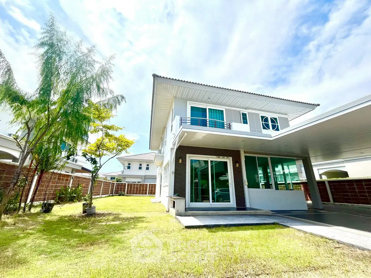 Stunning modern two-story house with spacious garden and large windows in a serene neighborhood.