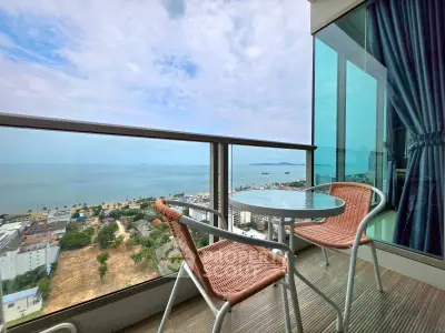 Stunning ocean view from a modern balcony with stylish seating, perfect for relaxation and enjoying the scenery.