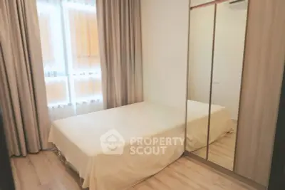 Cozy bedroom with mirrored wardrobe and soft lighting, perfect for relaxation.