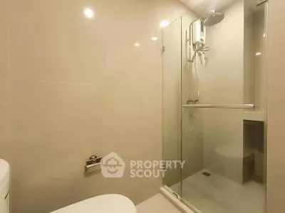 Modern bathroom with glass shower enclosure and sleek fixtures.