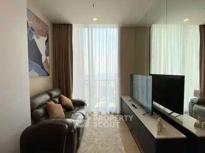Modern living room with leather sofa and large TV, featuring floor-to-ceiling windows and stylish decor.