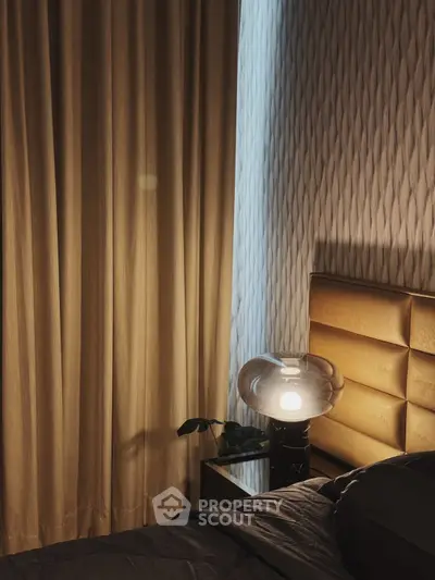 Cozy bedroom corner with elegant lighting and textured wallpaper