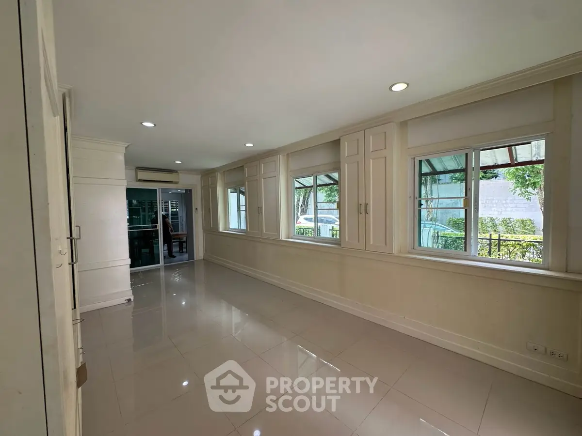 Spacious room with large windows and glossy tiled floor, perfect for natural light and modern living.