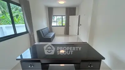 Spacious living room with modern furniture and large windows offering natural light.